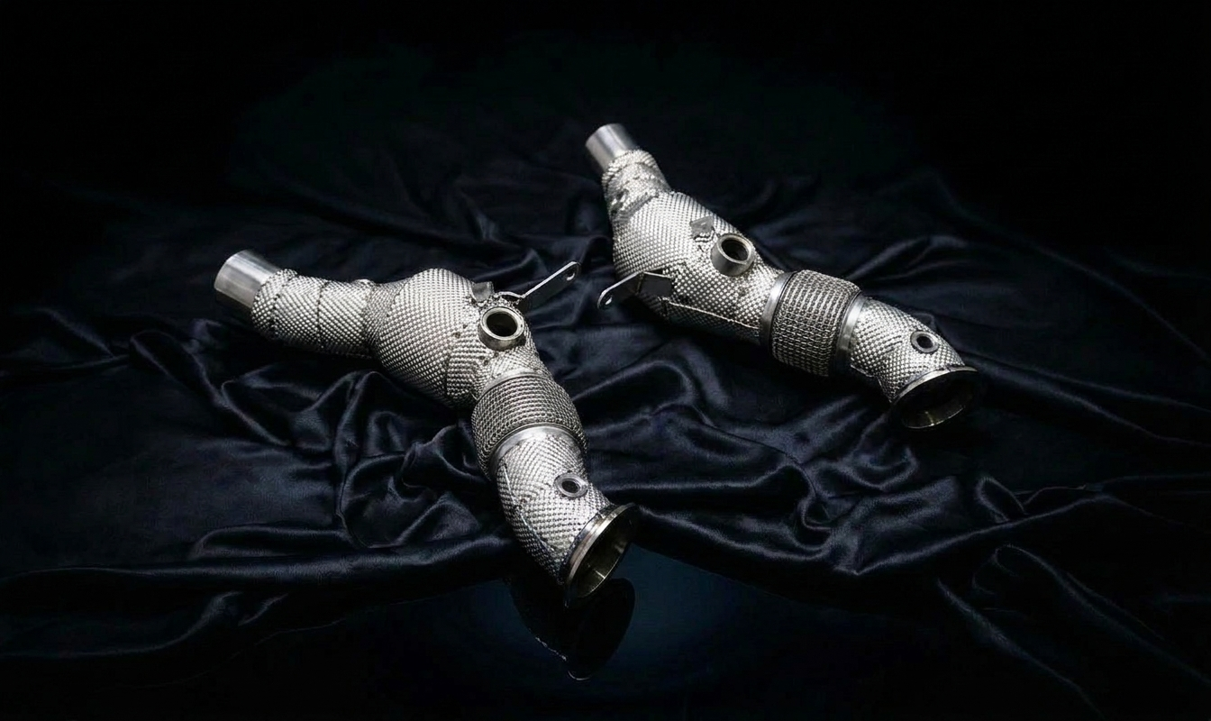 Ferrari SF90 downpipes detail — heat-shielded sport cats